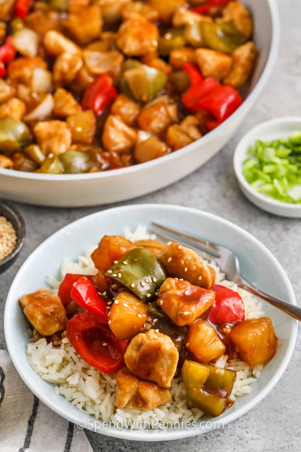 plated Sweet and Sour Chicken with pan full in the back