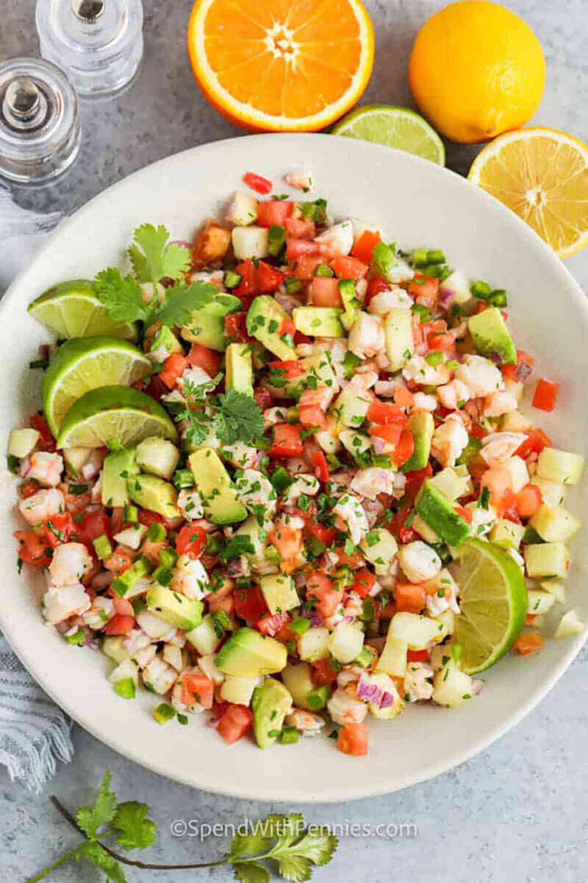 Have the taste of Mexico at home with this shrimp ceviche recipe. This easy no-cook salad won't take long to make. Low in calories and super healthy, shrimp ceviche is a salad for everyone. This colorful, crunchy, and flavorful salad is made with an abundance of vegetables including avocado and jicama. #spendwithpennies plated Shrimp Ceviche