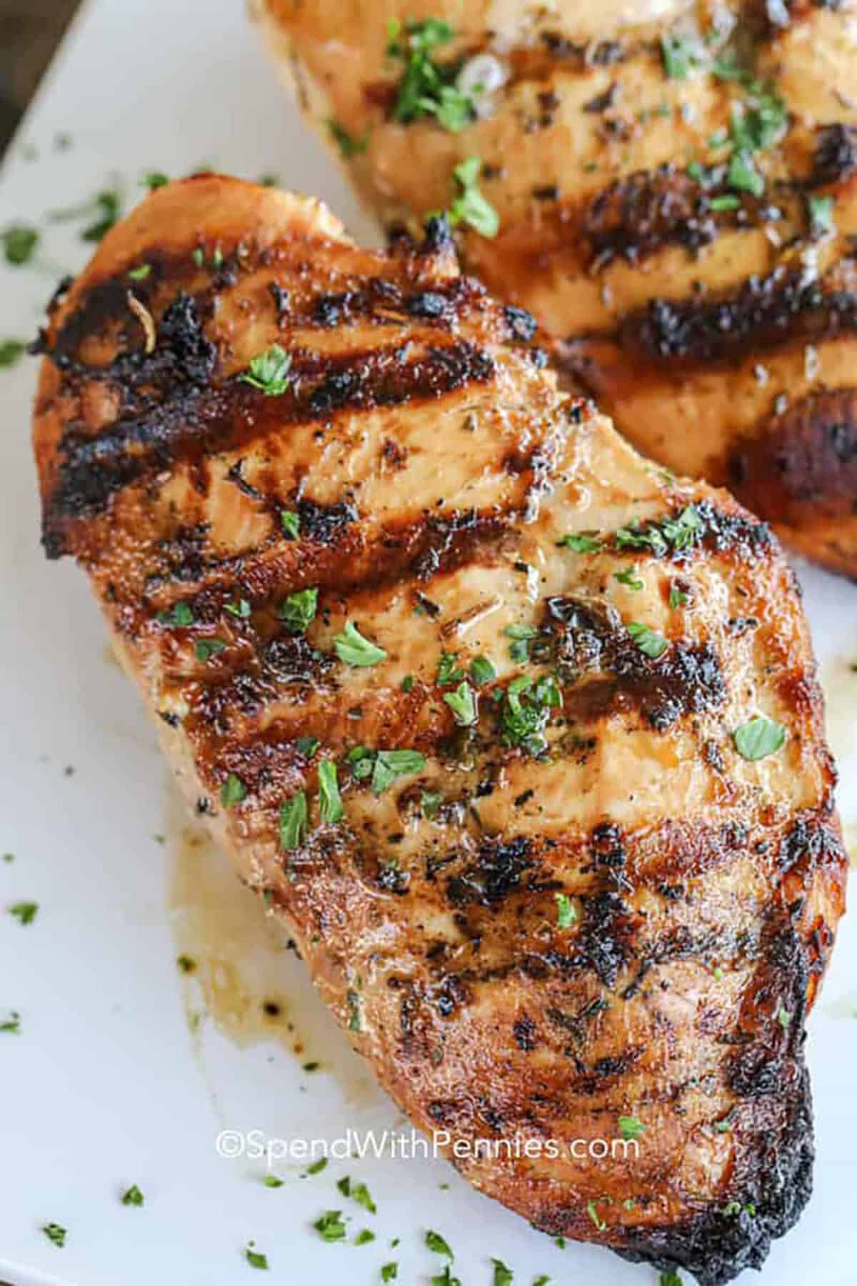 This easy chicken marinade brings the best homemade flavor to grilled chicken breasts. A simple mix of Dijon, lemon juice, soy sauce, and garlic powder makes each bite juicy and tender. Perfect for a quick weeknight dinner or a backyard BBQ, this recipe is as versatile as it is delicious. Grill, bake, or broil and serve with your favorite sides! #spendwithpennies cooked chicken breast with The Best Chicken Marinade