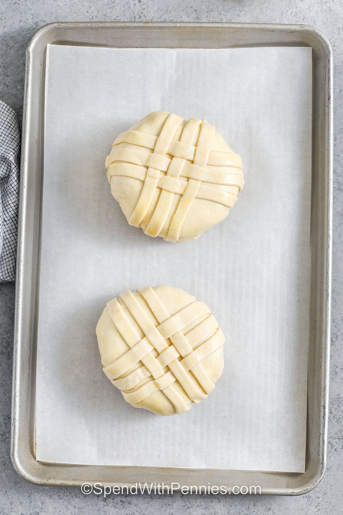 This Beef Wellington recipe takes filet mignon to the next level! Wrapped in prosciutto, topped with a rich mushroom mixture, and baked in a flaky puff pastry crust—it’s full of cozy, savory flavor in every bite. It's a great dish when you want to make something that really feels like a treat. You can even decorate the top with leftover pastry for a little extra flair. #spendwithpennies Beef Wellington on a sheet pan before cooking
