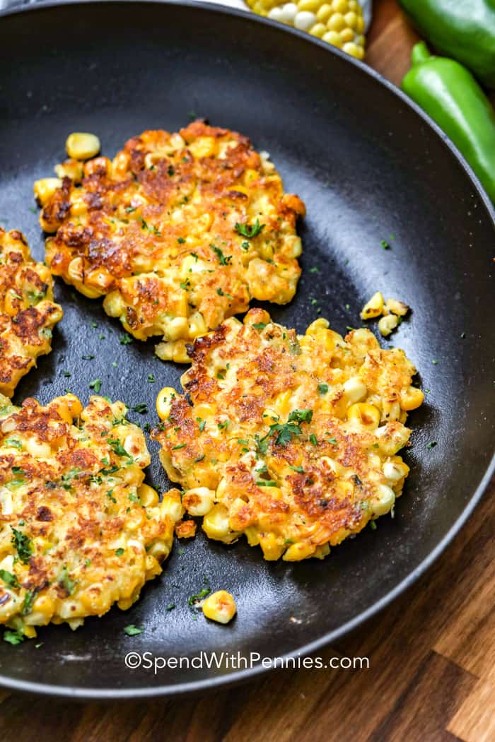 Corn fritters are crispy and golden with a tender inside that’s full of flavor. This easy recipe starts with cornmeal, sweet corn, and shredded jack cheese, with a dose of heat from smoked paprika and jalapenos. Add zucchini or shredded potato for a veggie-packed twist. They fry up perfectly every time and go great with beef, chicken, or even just on their own. Serve warm with sour cream or dip them in spicy sauce for a fun side or snack. #spendwithpennies Corn Fritters in a frying pan with jalapenos