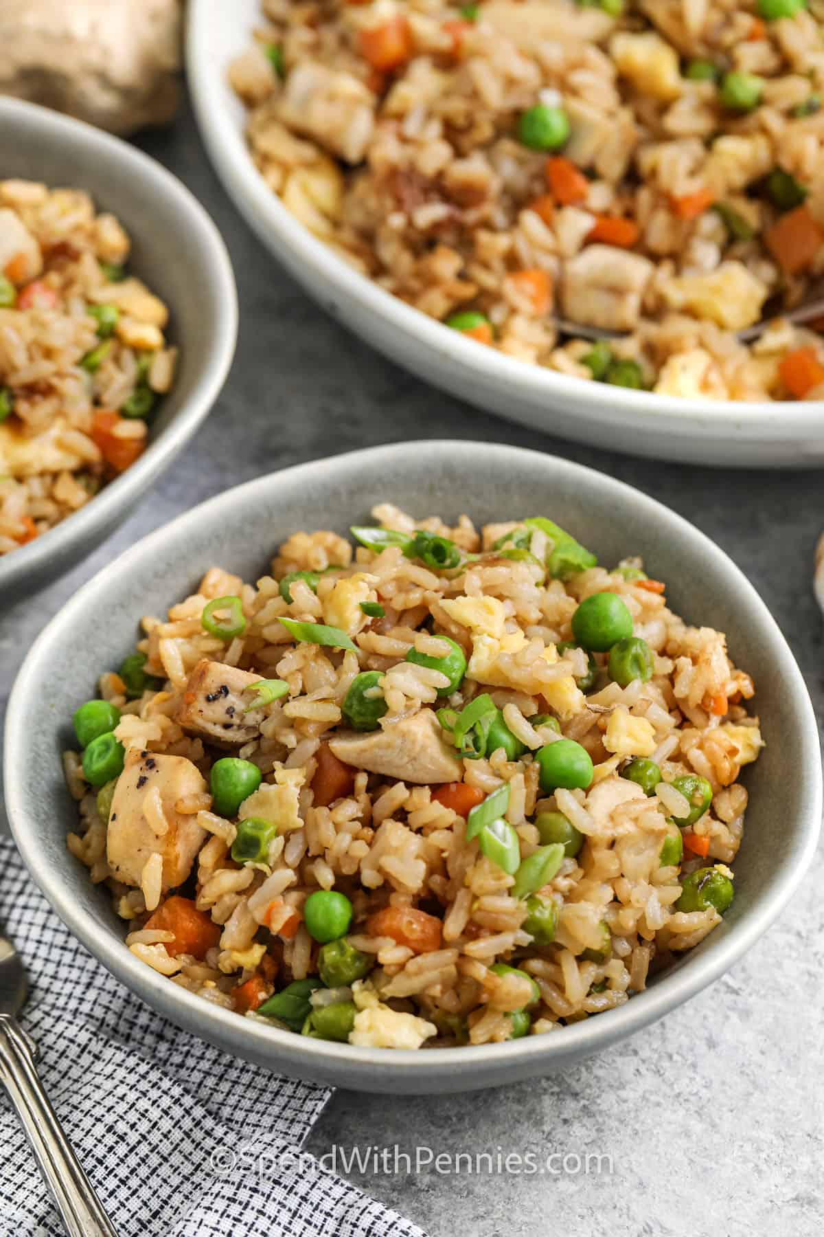 Chicken fried rice is the kind of recipe that makes dinner easy and satisfying. It starts with cold cooked rice and ends with a dish packed with flavor from garlic, soy sauce, and sesame oil. Add whatever protein you have on hand—chicken, pork, or shrimp all work! It’s a family favorite for a reason. #spendwithpennies bowls of Easy Fried Rice Recipe