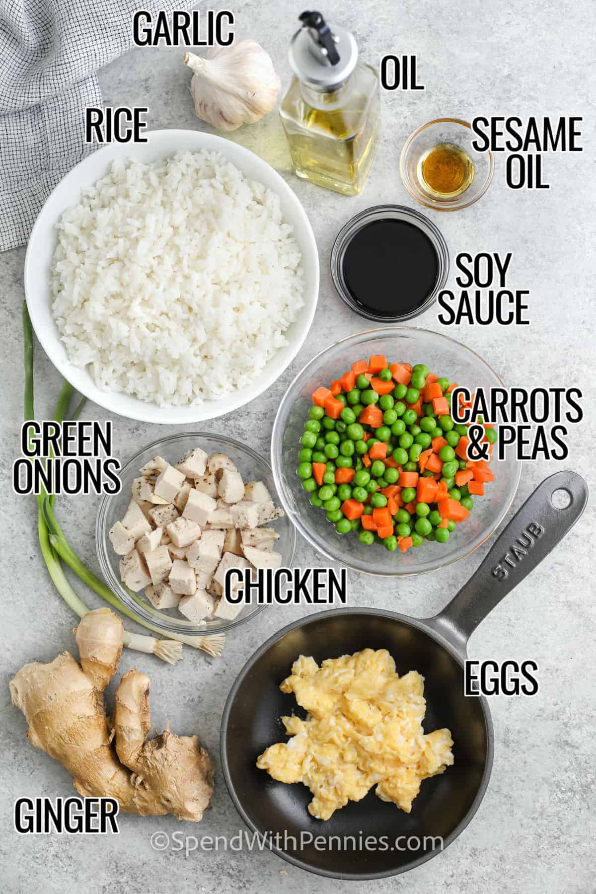 Chicken fried rice is everything you love about takeout, but homemade and even better. Fresh ginger, garlic, and green onions bring bold flavor, while the rice gets golden and crispy in the pan. Stir in cooked chicken and it’s a full meal in one skillet. You’ll want to keep this recipe on repeat. #spendwithpennies rice , garlic , oil , sesame oil , soy sauce , green onions , chicken , ginger , eggs , carrots and peas with labels to make Easy Fried Rice Recipe