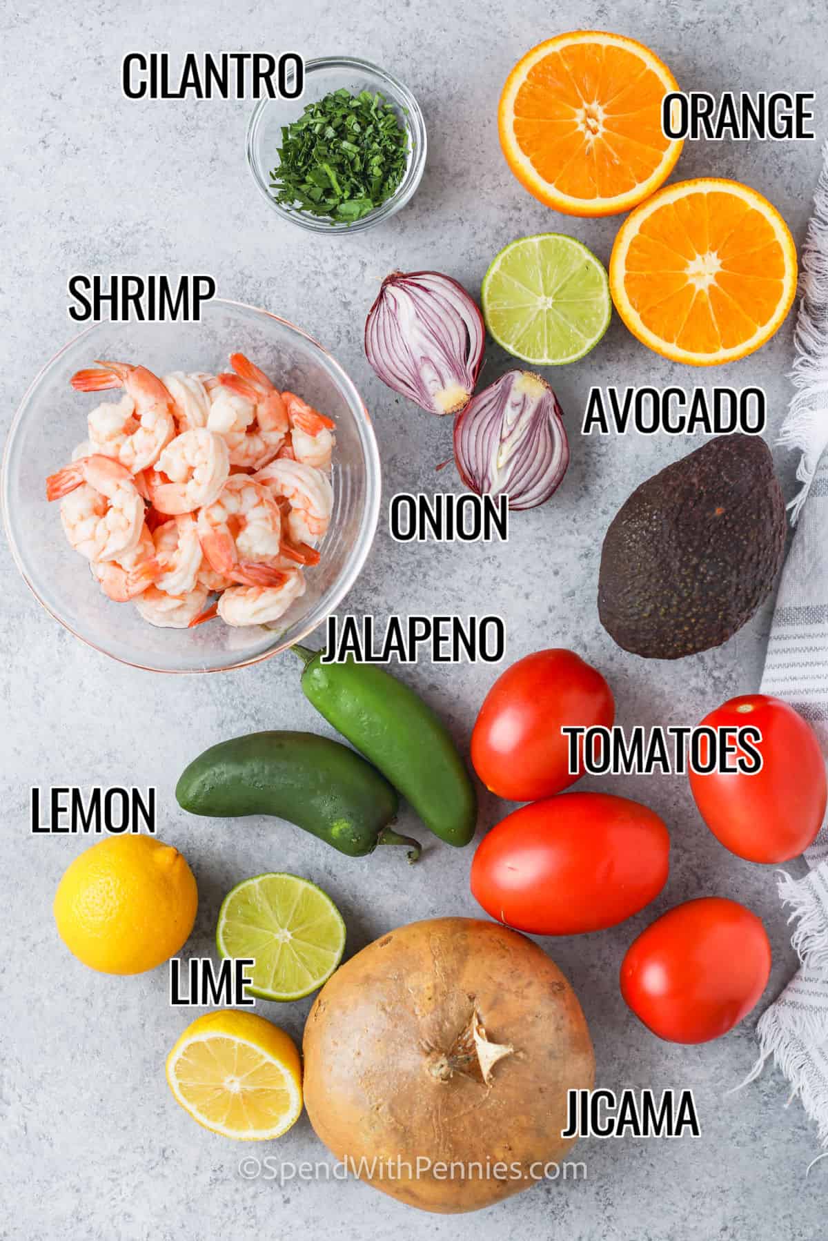 Make the tastes of Mexico with this shrimp ceviche recipe. This easy no-cook salad is ready in minutes with no cooking required. Healthy and low in calories, this shrimp ceviche is sure to please everyone. Made with tomatoes, jicama, peppers, cilantro, and onions, and topped with some avocado, this salad is colorful, flavorful, and crunchy! #spendwithpennies shrimp , avocado , tomatoes , onion , lemon , limes and other ingredients to make Shrimp Ceviche with labels