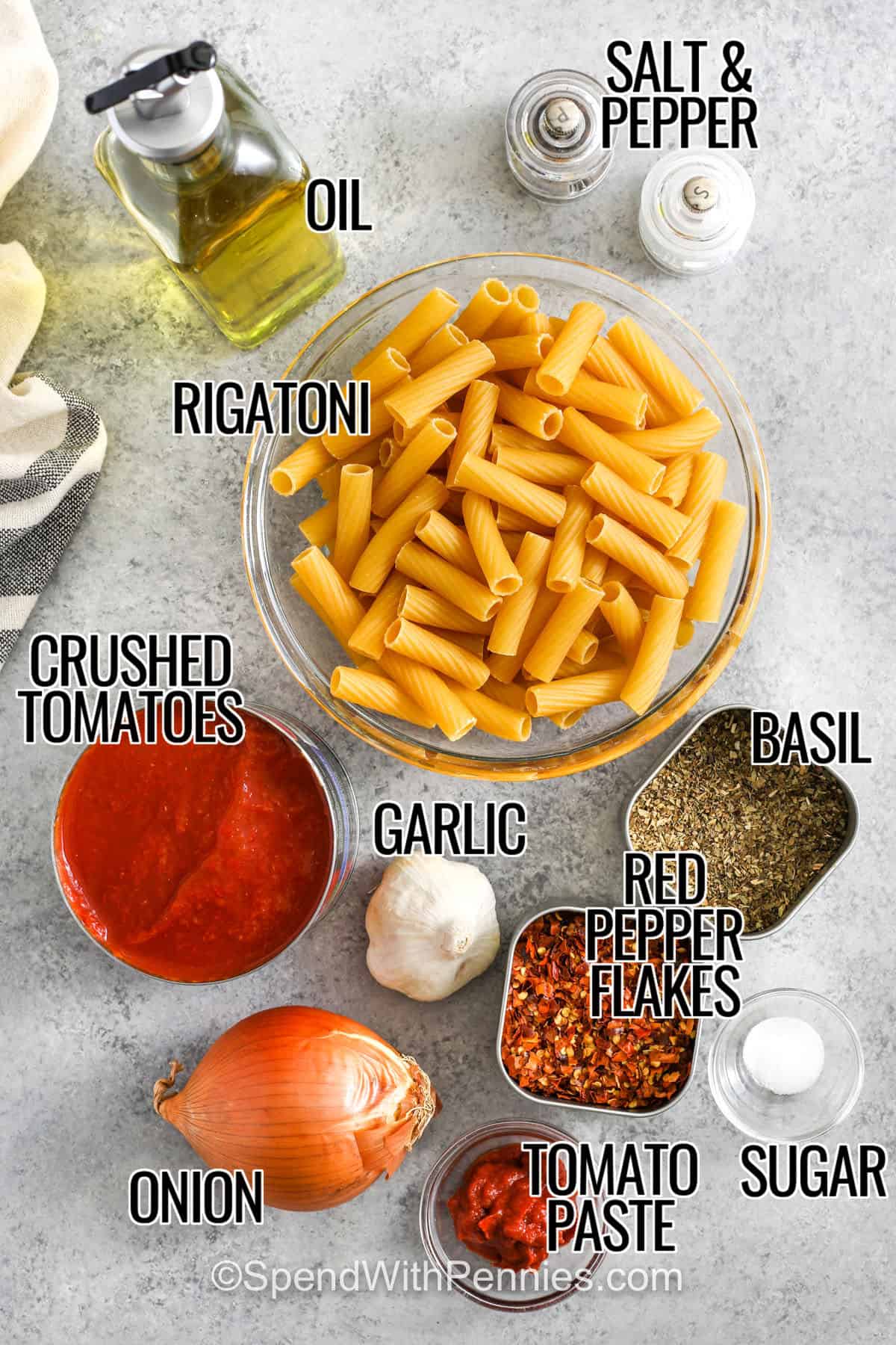 Rigatoni Arrabbiata is a spicy, bold pasta dish that’s easy to whip up with pantry ingredients! Crushed tomatoes, red chili flakes, and garlic bring heat and flavor, while rigatoni soaks up every saucy bite. Perfect for weeknights or when cravings strike, it’s ready in about 30 minutes. A sprinkle of parmesan and fresh herbs takes it over the top! #spendwithpennies oil , rigatoni , crushed tomatoes , garlic , onion , tomato paste , sugar , red pepper flakes , basil with labels to make Rigatoni Arrabbiata