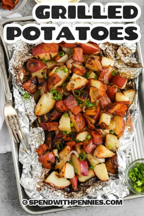 Grilled potatoes are the perfect side for anything coming off the BBQ! Tossed with onions, garlic, and buttery rosemary, they cook up tender with golden edges in a handy foil packet. No peeling, no fuss—just big flavor in every bite. Whether it’s burgers, BBQ chicken, or shrimp kabobs, these potatoes fit right in with all your summer favorites! #spendwithpennies Grilled Potatoes in tin foil and writing