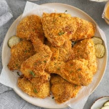 Oven Fried Chicken on a plate with a plate of corn and mashed potatoes