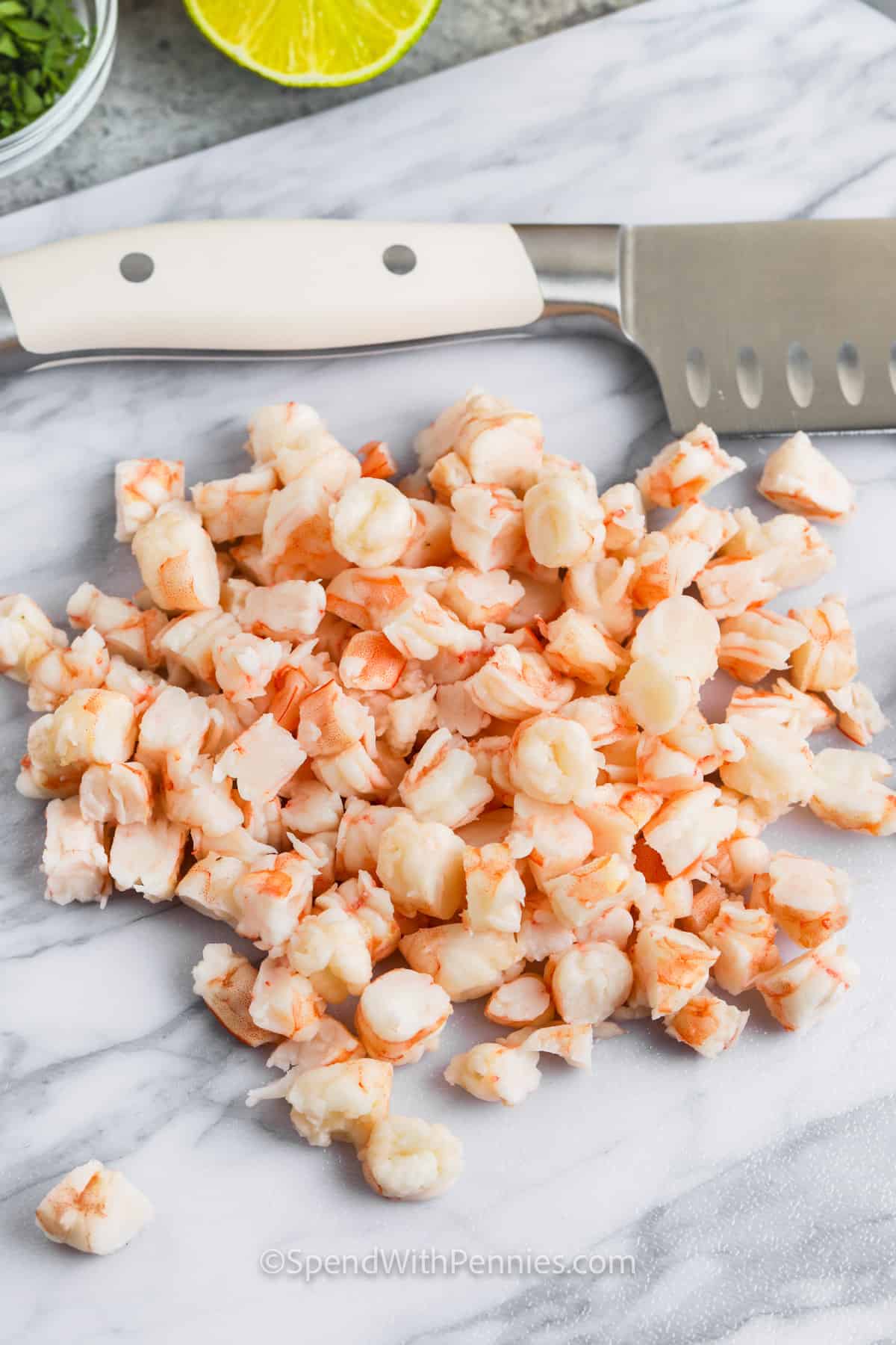 Make the foods of Mexico at home with this shrimp ceviche recipe. It won't take long to cook this easy salad. Made with an abundance of vegetables like jicama, onions, tomatoes, and peppers, this salad is so healthy and low in calories. This is the best in Mexican cuisine. #spendwithpennies cutting shrimp to make Shrimp Ceviche