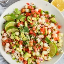 top view of Shrimp Ceviche in a bowl with lemons and limes around it