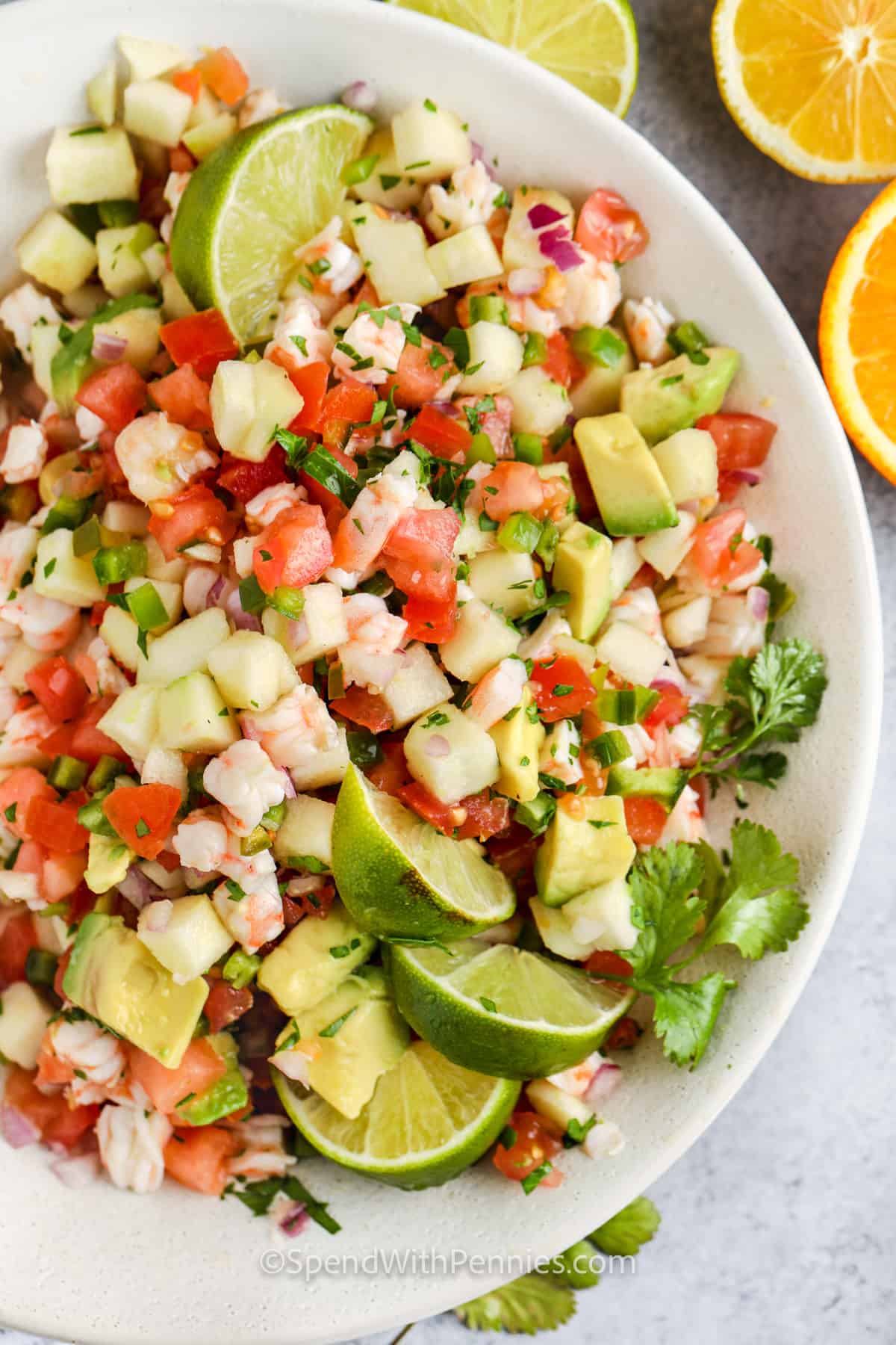 It is so easy to have the flavors of Mexico at home with this shrimp ceviche recipe. Have this easy no-cook salad ready in no time. It will be hard to beat such a flavorful salad that is so healthy and low in calories. Jicama, onions, tomatoes, cilantro, and some avocado are combined making this a crunchy and colorful salad that is just bursting with flavor. #spendwithpennies plated Shrimp Ceviche with limes