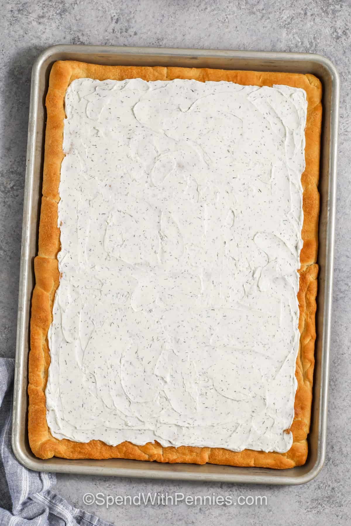 veggie pizza crust with creamy sauce in a pan