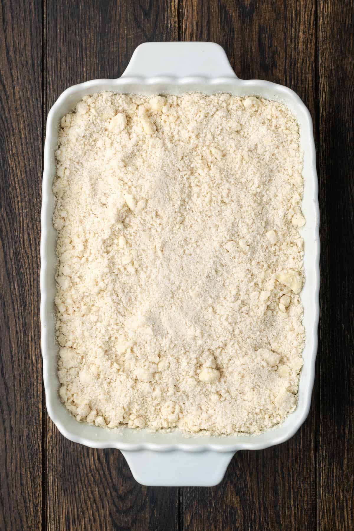 Crumble topping added over the strawberry filling in a baking dish.