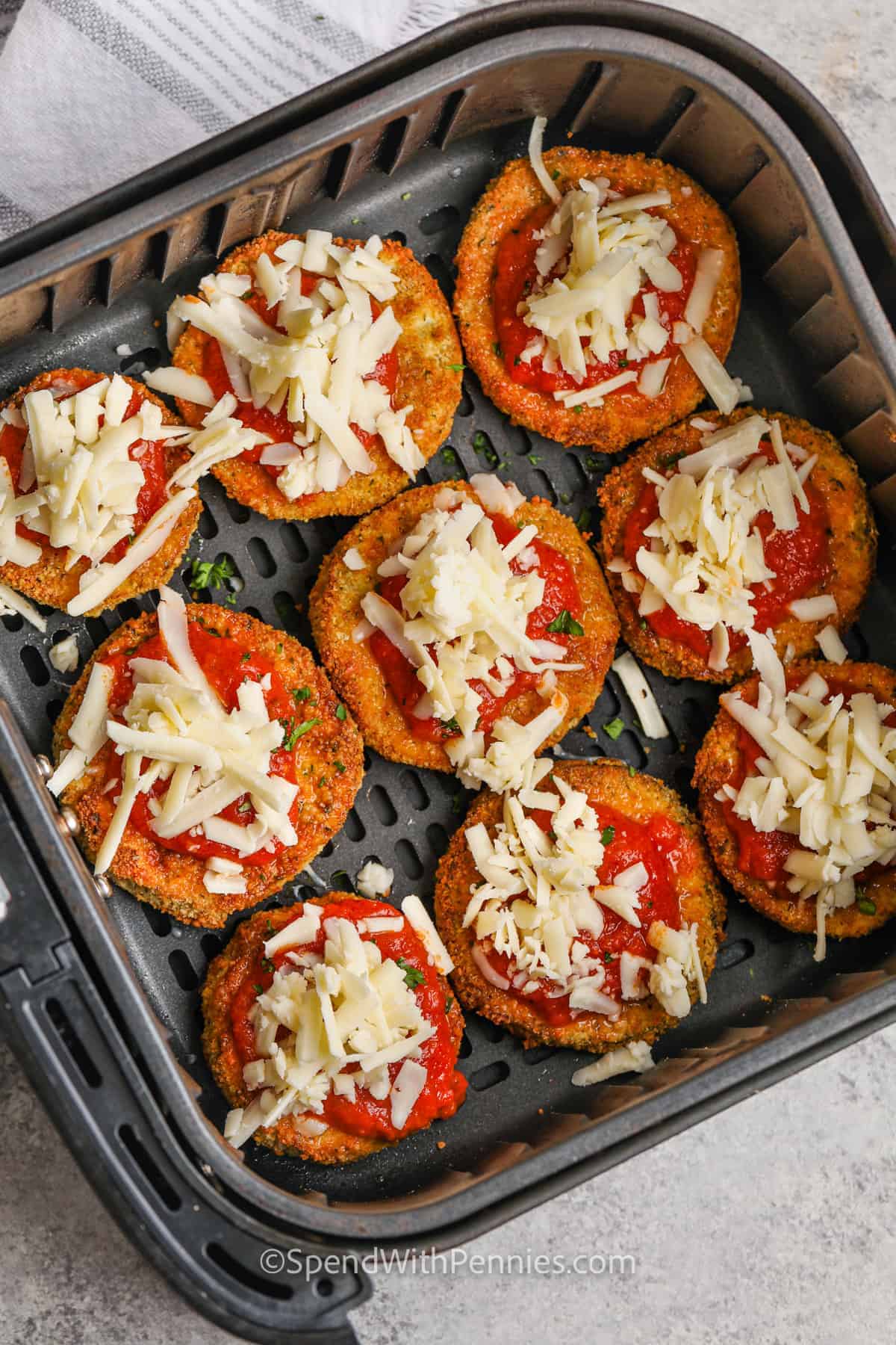 This air fryer eggplant parmesan recipe is an easy way to enjoy a fried favorite without the extra oil. The eggplant gets breaded, crisped up in the air fryer, and finished with marinara and melty mozzarella. It’s a great dish to cook when you want something cozy but lighter. Want a keto version? Just leave out the breadcrumbs. You can even swap in chicken for a protein-packed twist. #spendwithpennies adding cheese to Air Fryer Eggplant Parmesan