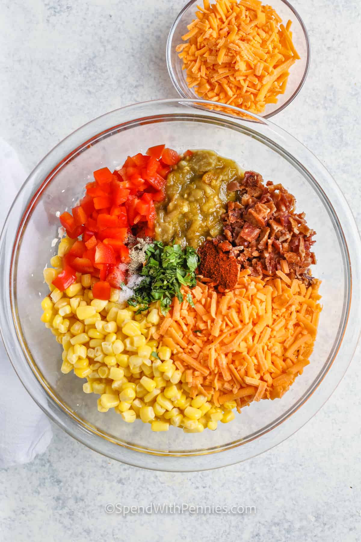Corn dip is a cheesy and creamy recipe that’s packed with bold flavor and always a hit at parties. Inspired by the street food flavors of Mexico, it’s made with corn, chili powder, cream cheese, and chiles, then baked hot until bubbly. Scoop it up with tortilla chips or serve it cold if you’re short on time. Add beef for a meaty twist, or make it meatless with black beans. #spendwithpennies ingredients in a bowl to make Creamy Baked Corn Dip