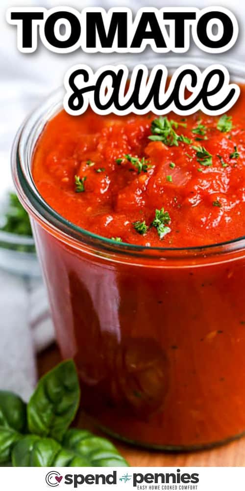 Tomato sauce from scratch is simple, satisfying, and so much tastier than anything from a jar. Sautéed onions and garlic lay the flavor foundation, while hand-crushed canned tomatoes, basil, and parsley add richness and herby brightness. This sauce is great to make ahead and freezes beautifully for future meals. A true recipe essential for pasta or spaghetti night! #spendwithpennies close up of Tomato Sauce with a title