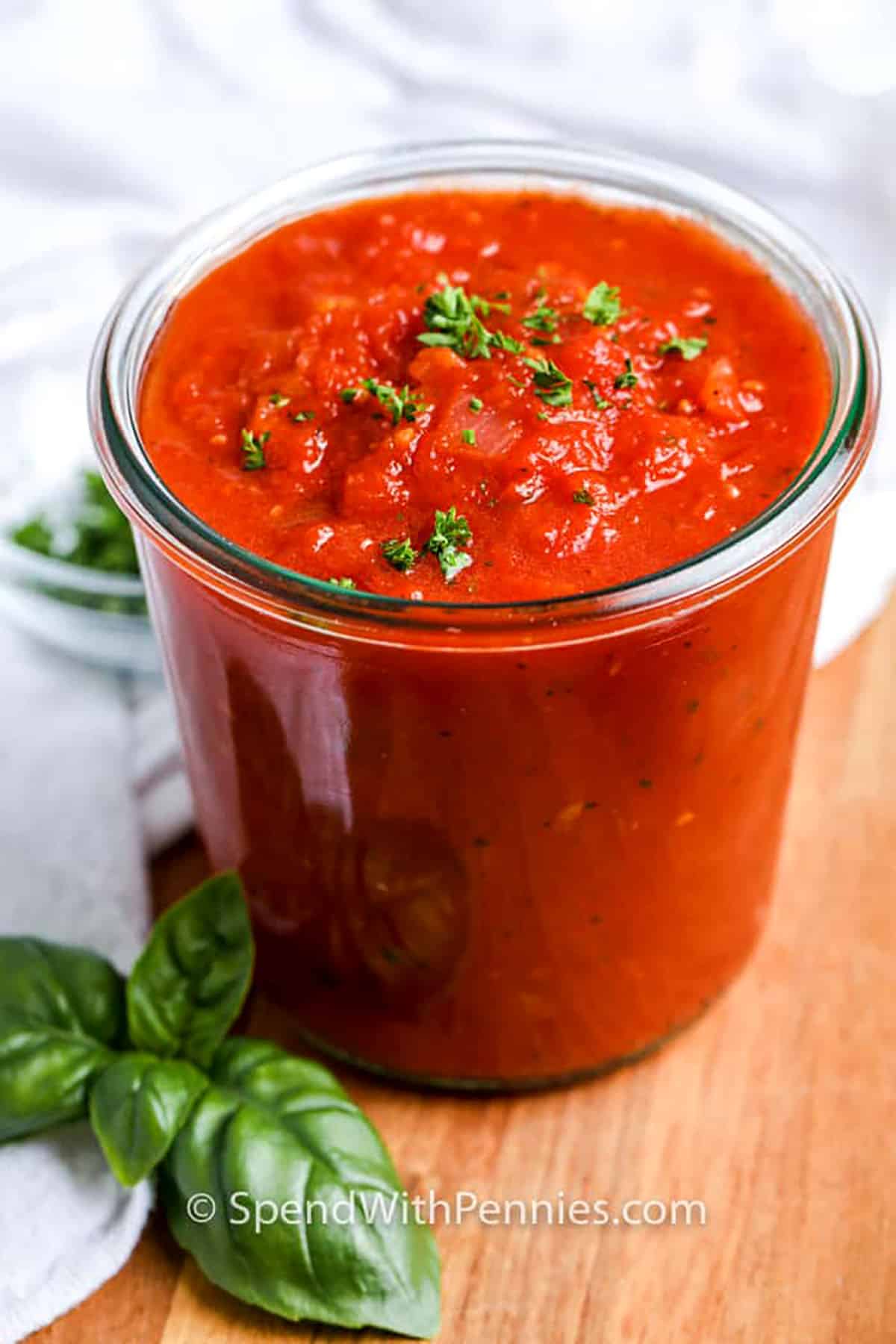 This homemade tomato sauce is made with pantry staples and delivers big flavor with minimal effort. Onions and garlic sautéed in olive oil form the base, while canned tomatoes, basil, and parsley add depth and freshness. It’s perfect for a quick weeknight dinner or to batch-cook and freeze. Blend it smooth or keep it chunky, it’s up to you! #spendwithpennies jar of Tomato Sauce